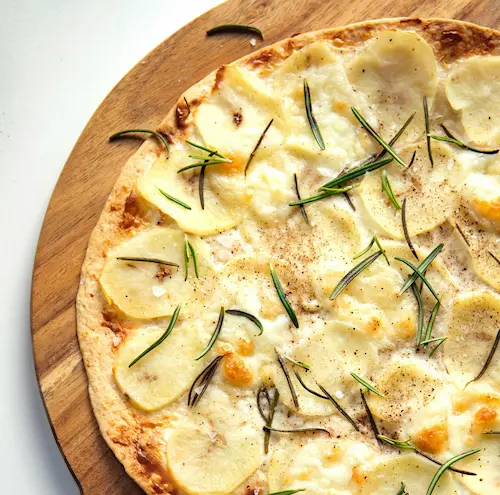 Potato pizza on a wooden board
